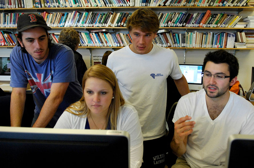 students around a computer in discussion