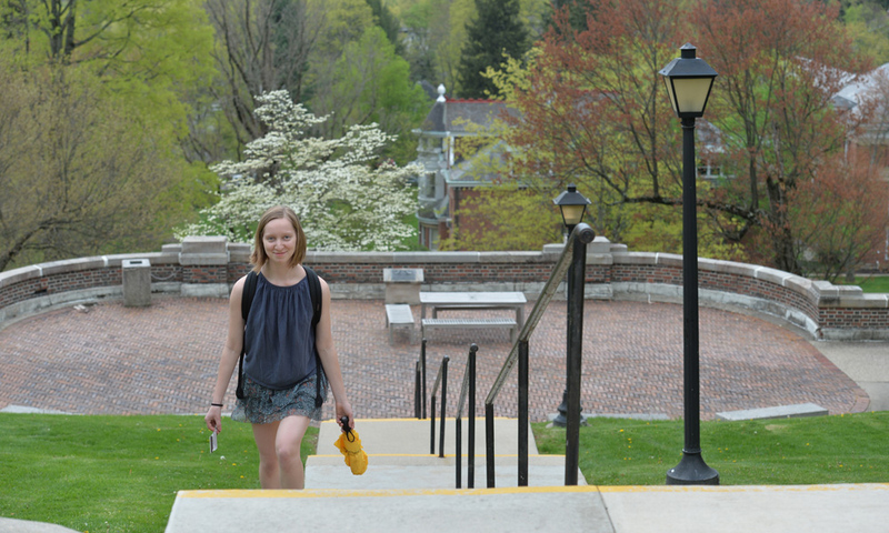 student walking up stairs with trees in the background