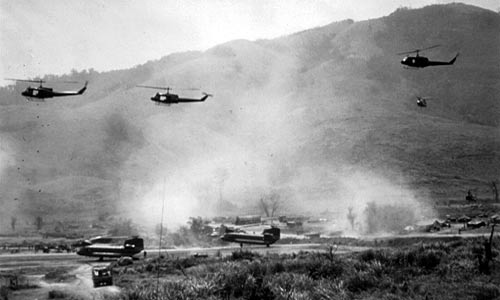 Black and white photo from the Vietnam Tragedy with helicopters and mountains in the background