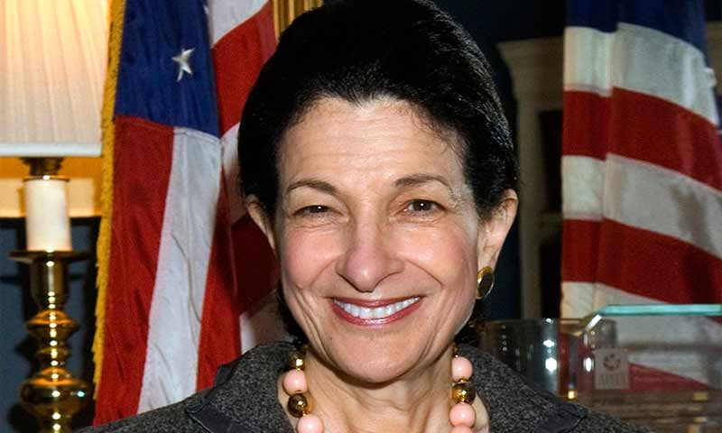 A portrait photo of Olympia Snowe posing with an American flag in the background