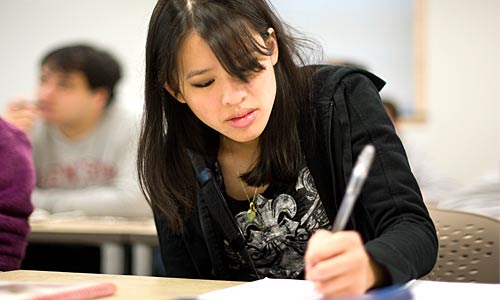 A student writes with a pen