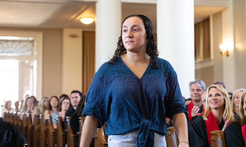 Ariela Katz ’22 walks up the aisle inside Swasey Chapel to receive her medal.