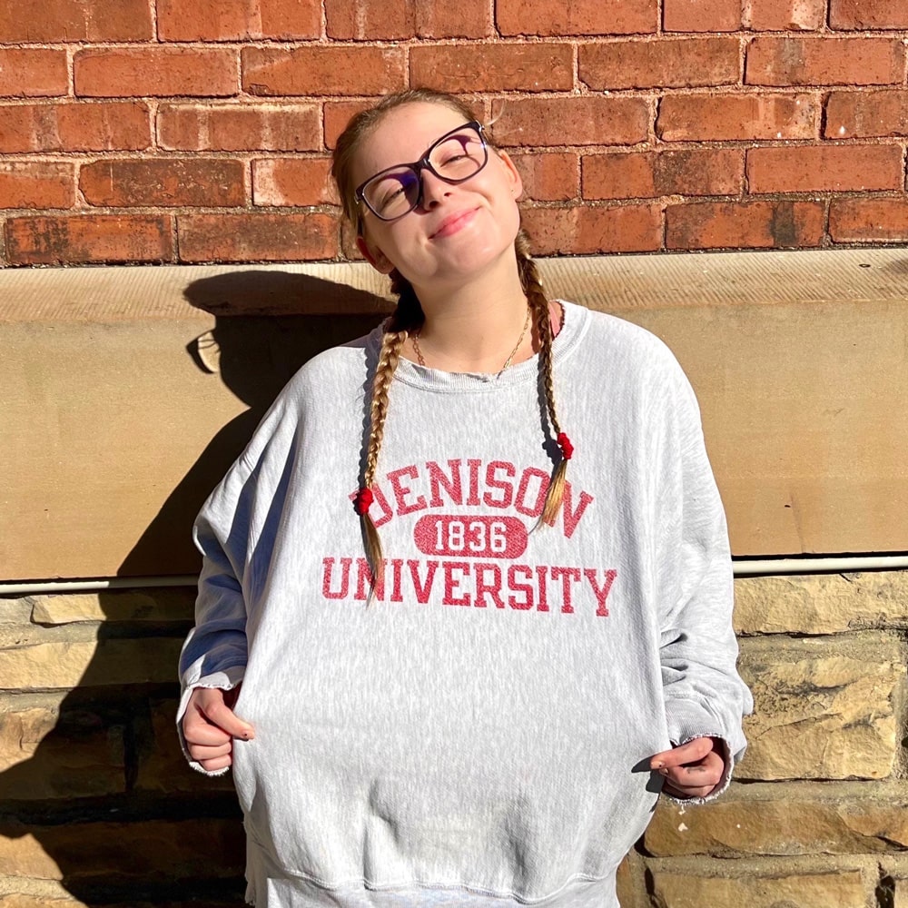 Payton Clew ’24 models the Denison sweatshirt that belonged to her father Stephen ’86 during his time at the university. Photo submitted by Clew.