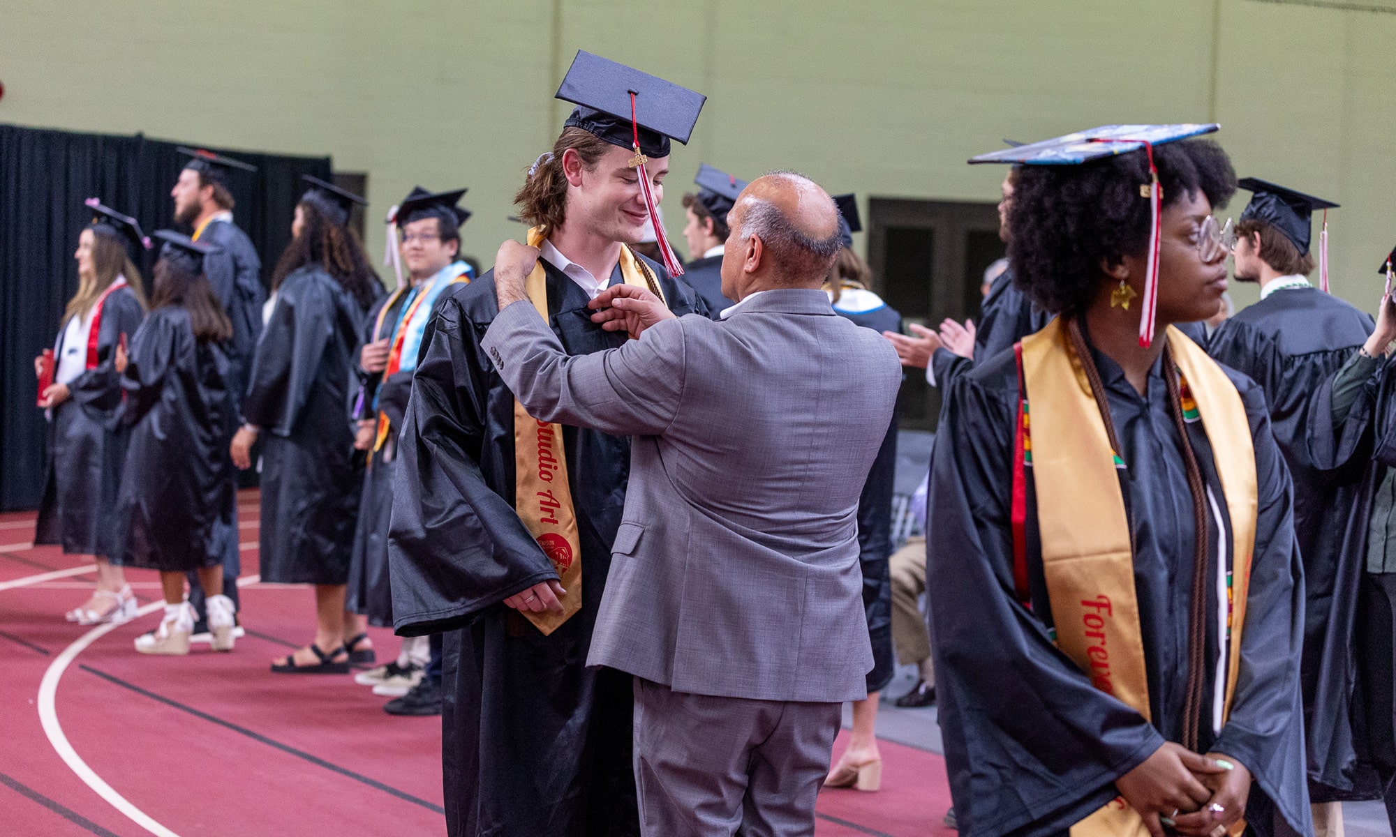 Raj Bellani fixing a graduates' stole before going on stage