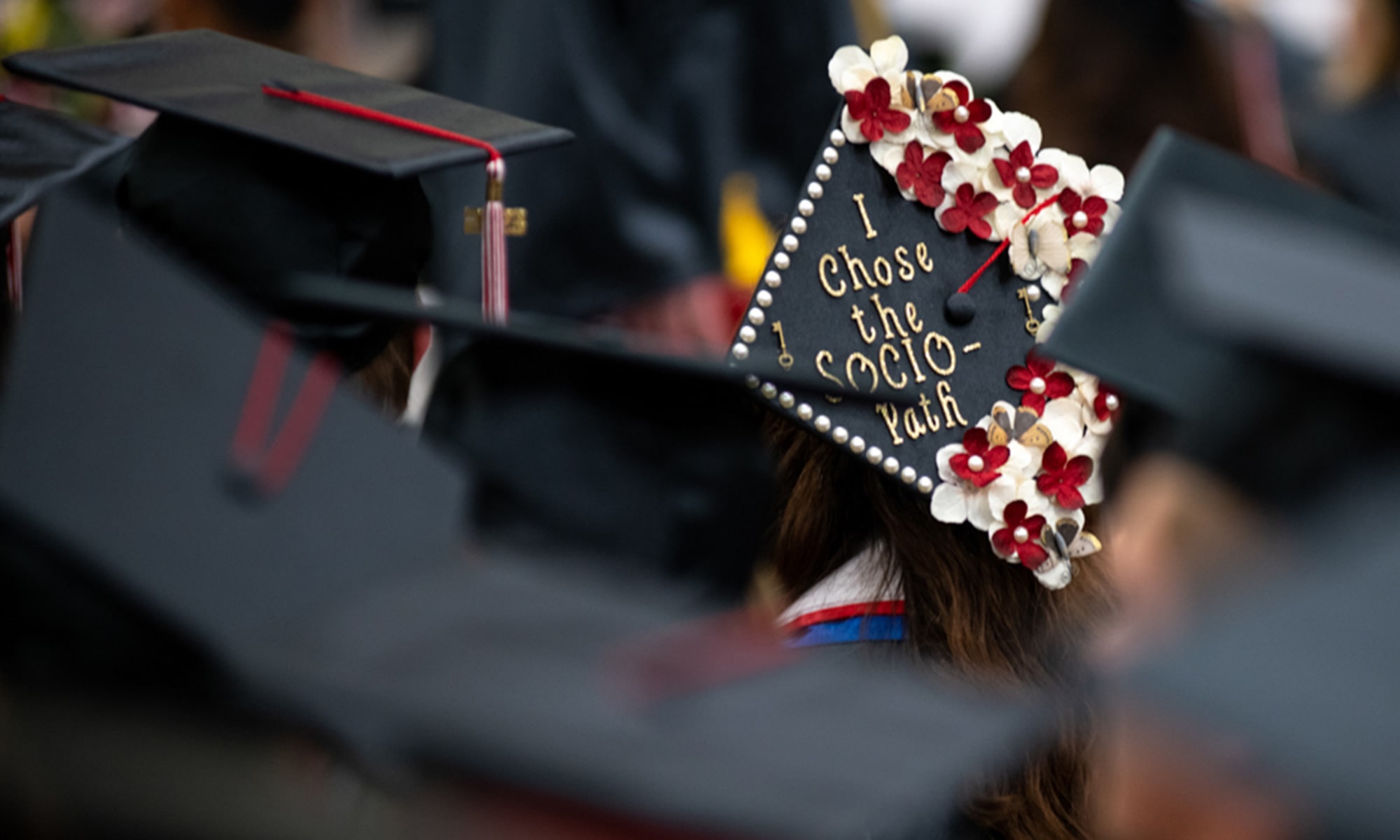 Student graduation cap decorated with flowers that reads 'I chose the socio-path'