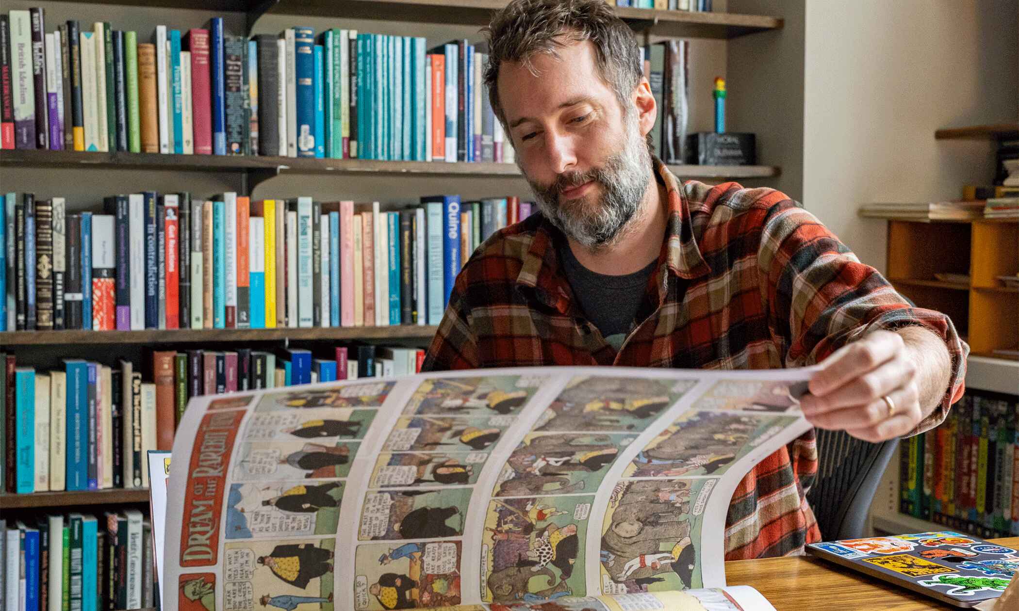 Sam Cowling peruses an oversized comic book.