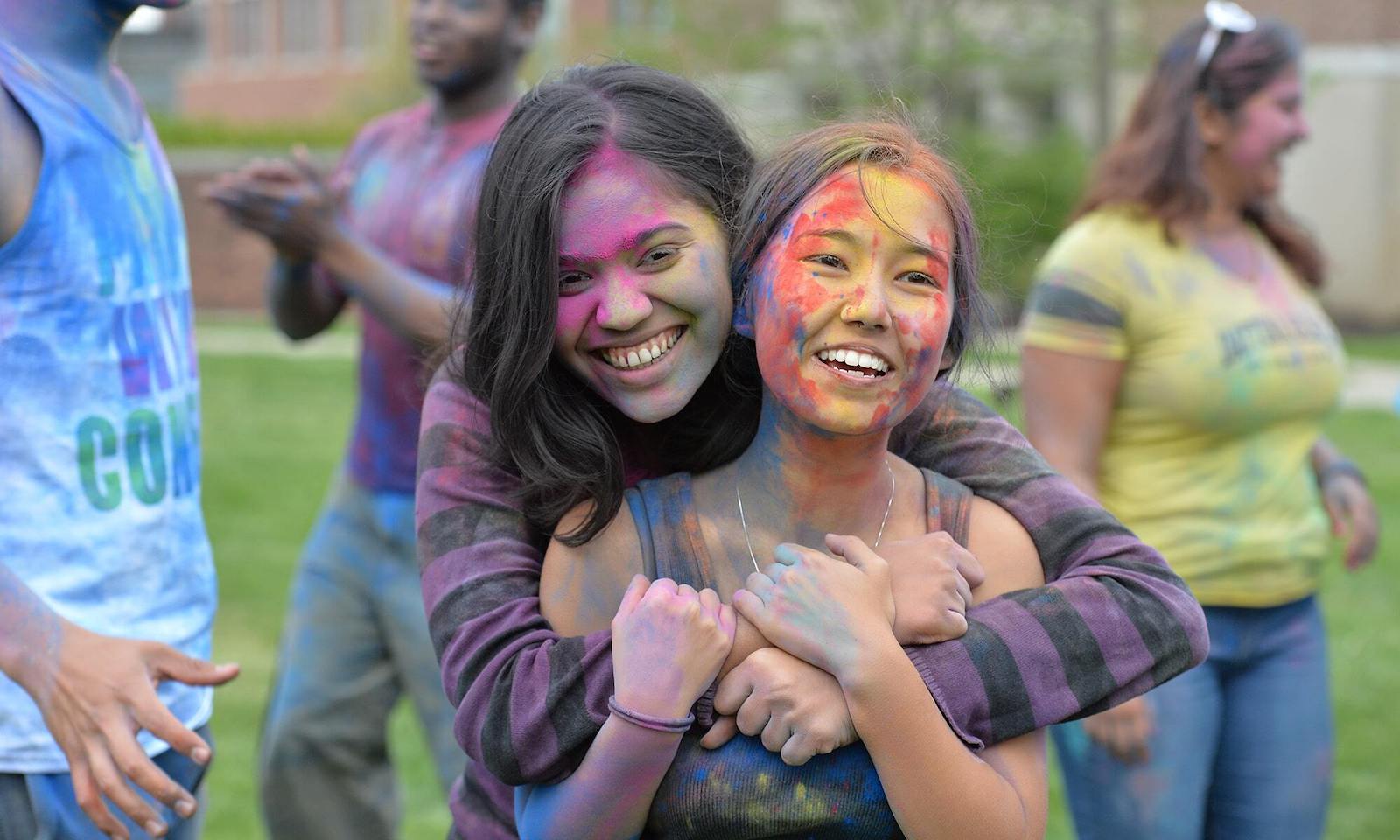 Two students covered in powdered paint at Aestavalia celebration