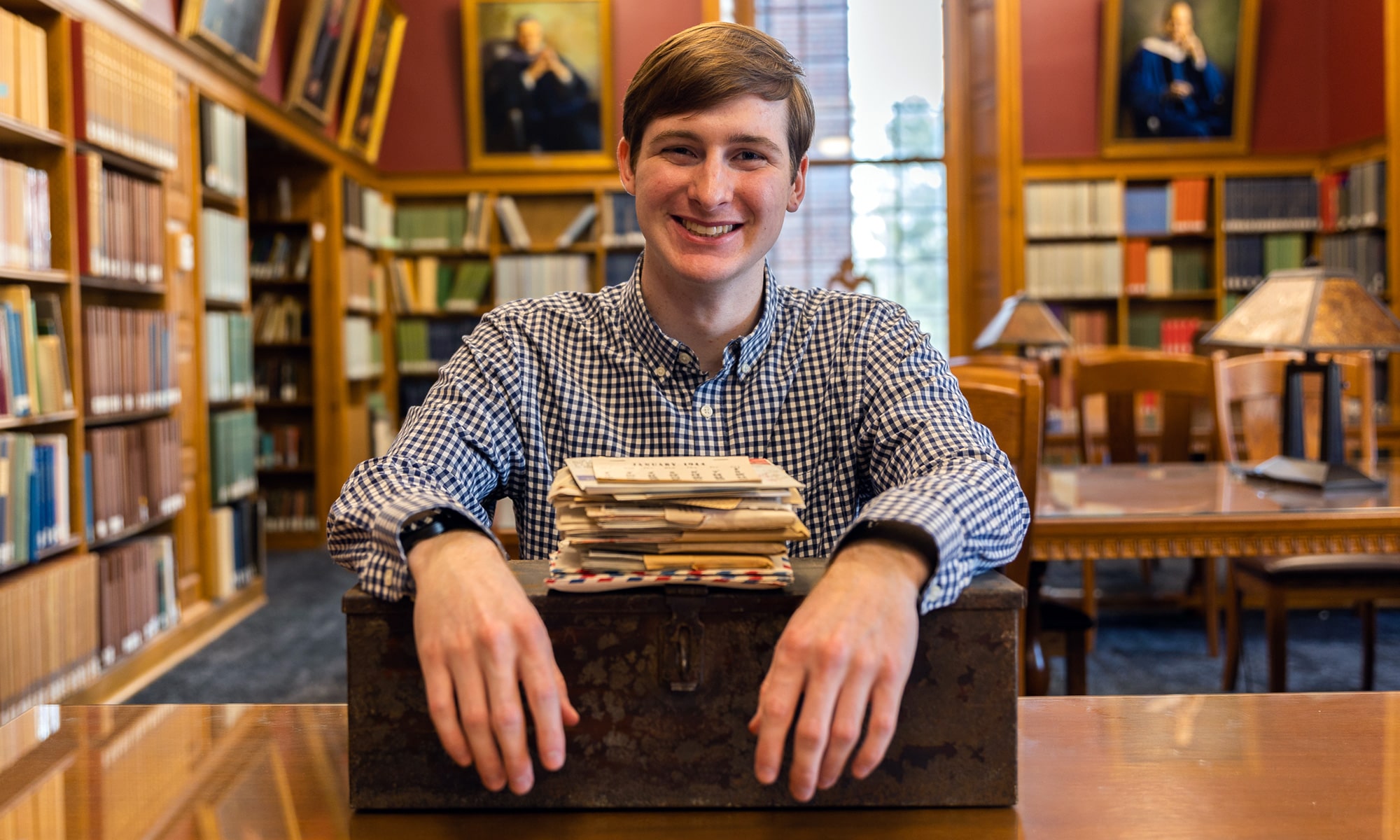 Carter Patton '23 with the letters and box in the library