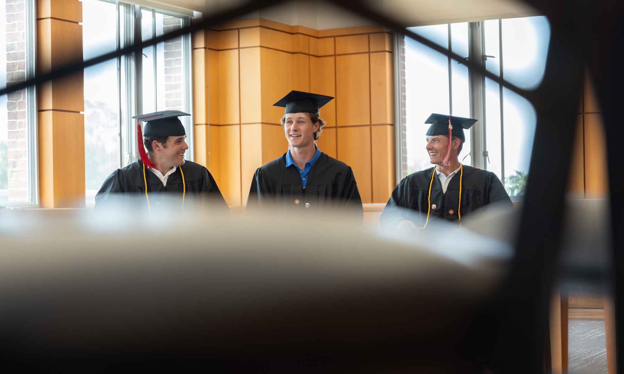 Graduating students are pictured in caps and gowns.