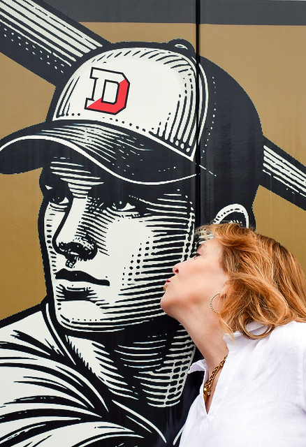 Lisa kisses the outfield wall graphic of her late husband, David Elliott ’87
