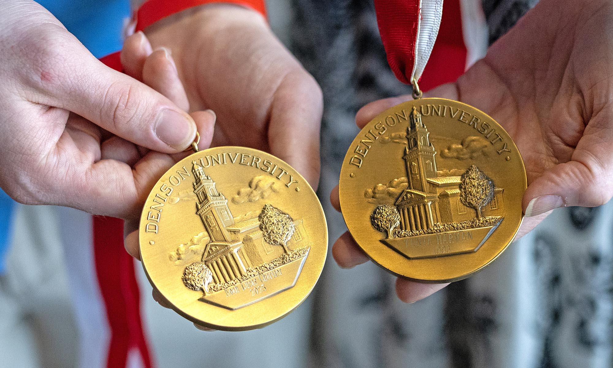 Close up photo of two Denison President's medals being held by Noah Chartier ’25 and his mother Tanya Harman Chartier ’93.
