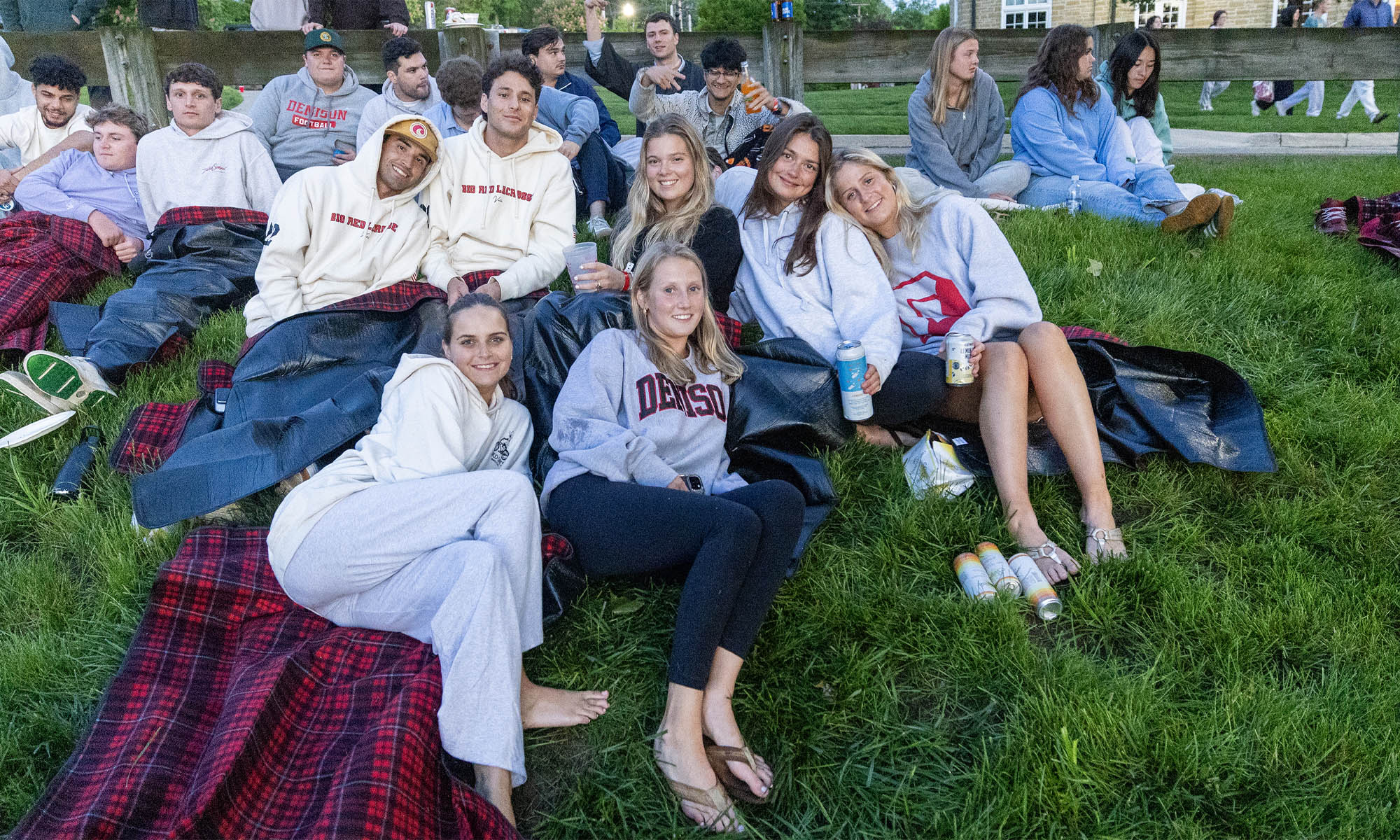 Seniors on Sigma Chi lawn smile at sunrise.