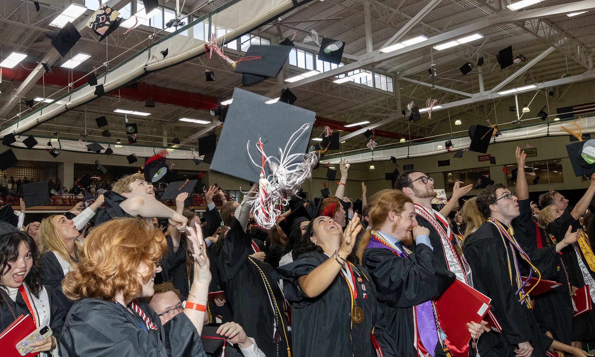 Denison grads toss their caps in the air in celebration at Commencement.