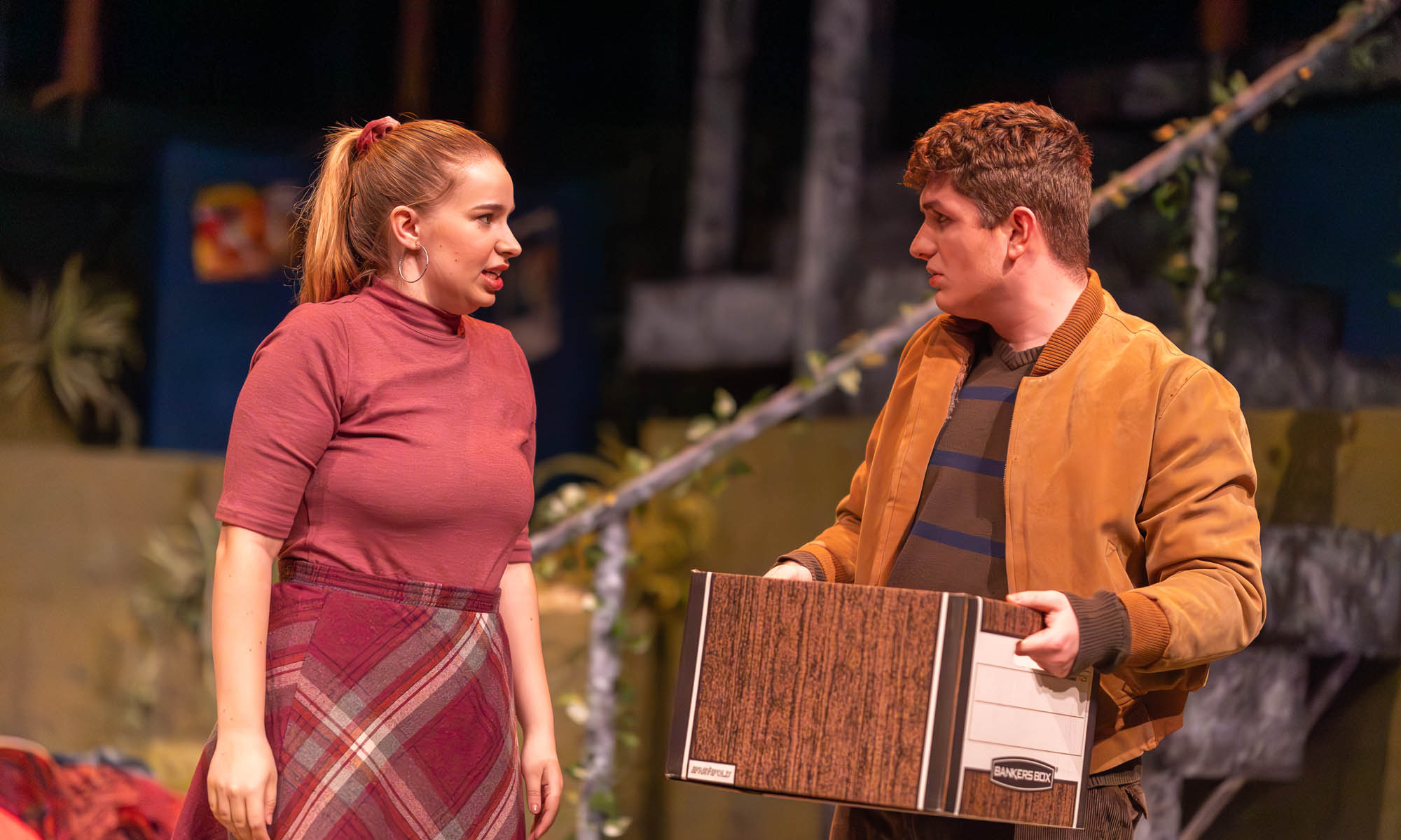 Theatre students performing on stage during a production.