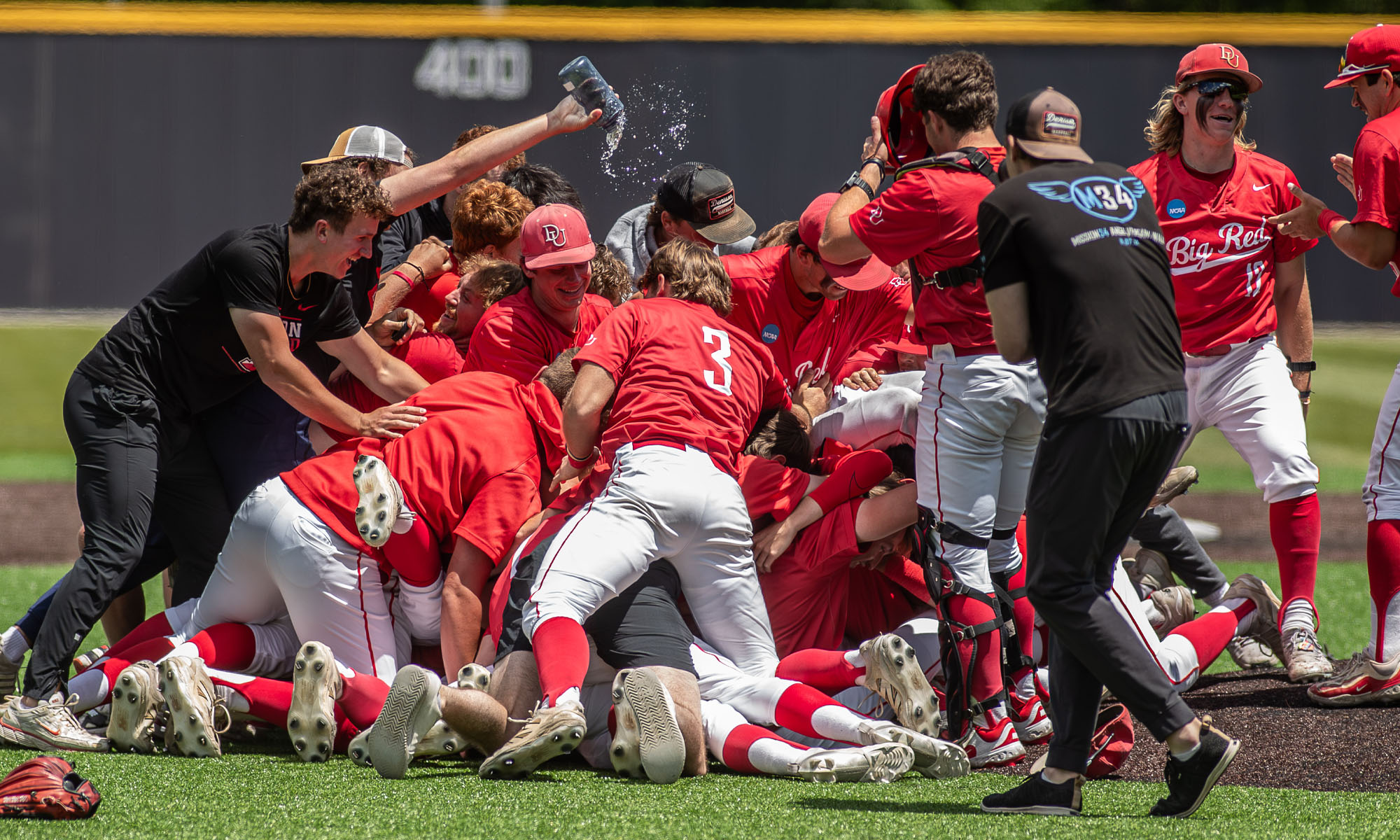 Photo of the men's baseball team celebrating on the field.