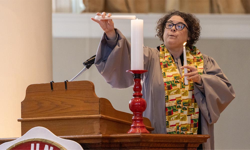 A person lights their candle.