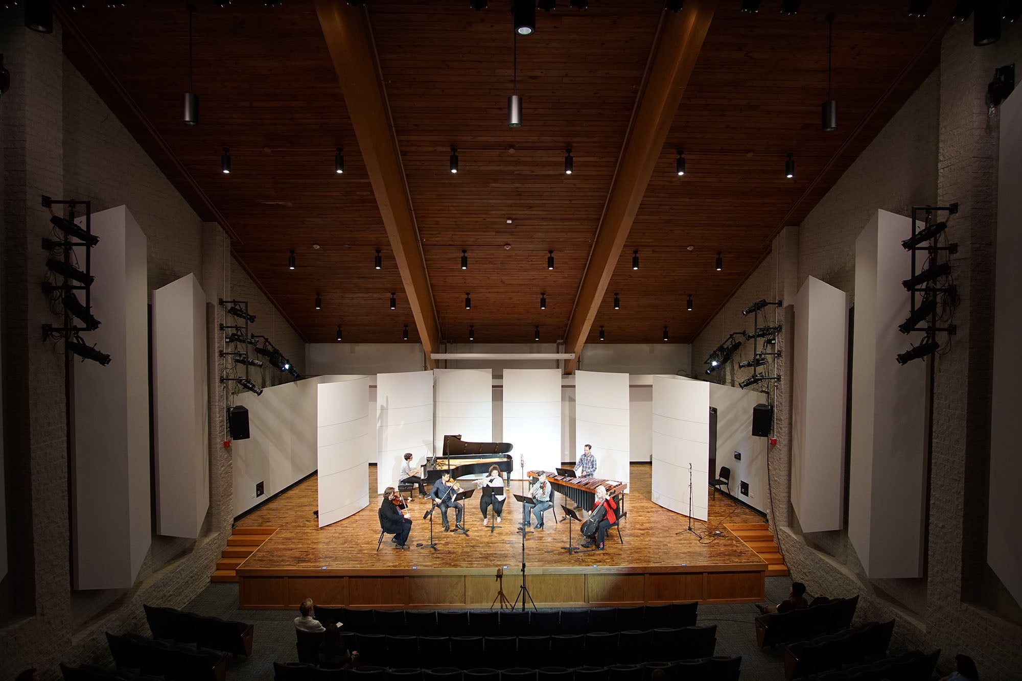 Photo of a recital hall with a wooden slope ceiling and sound boards on the walls.