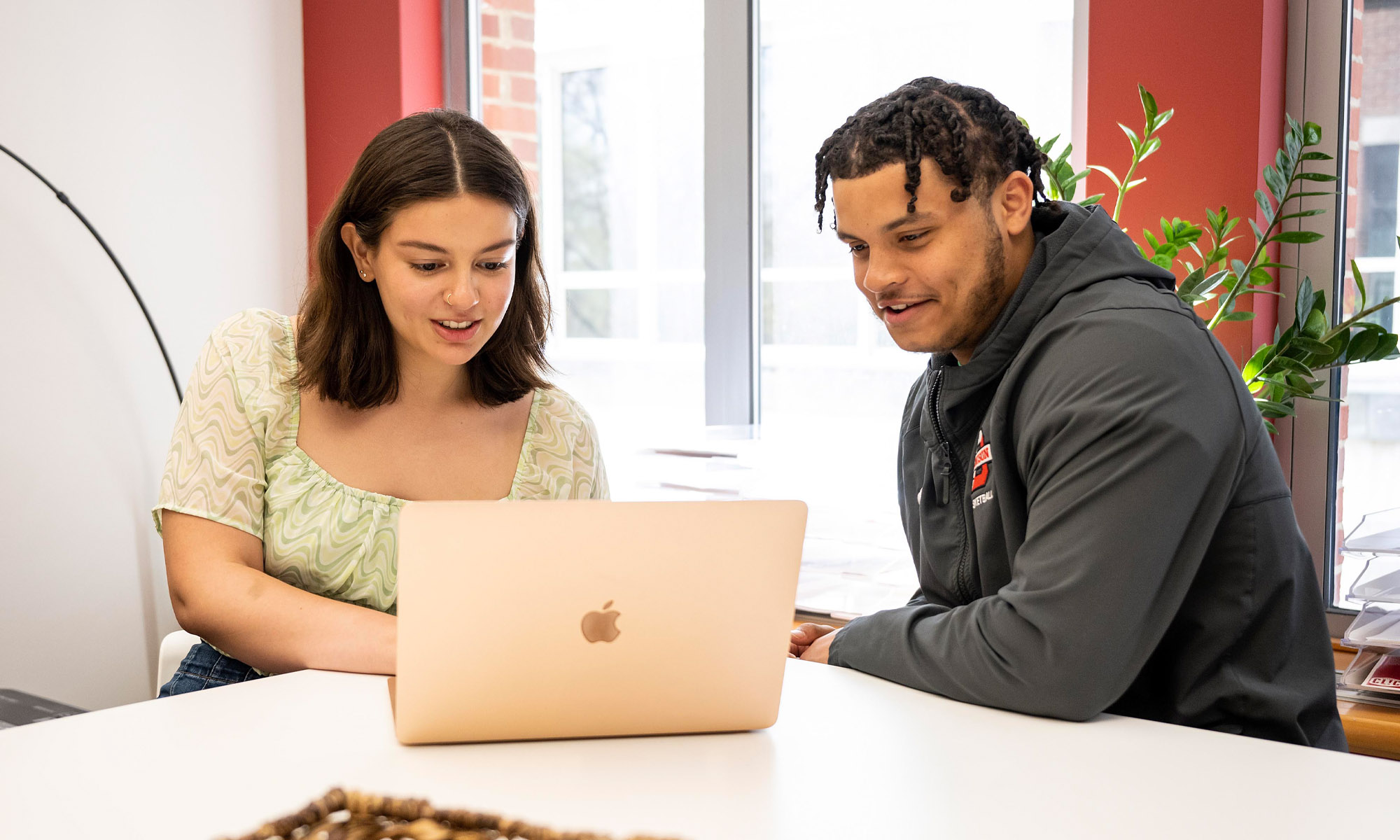 Students sitting at a laptop.
