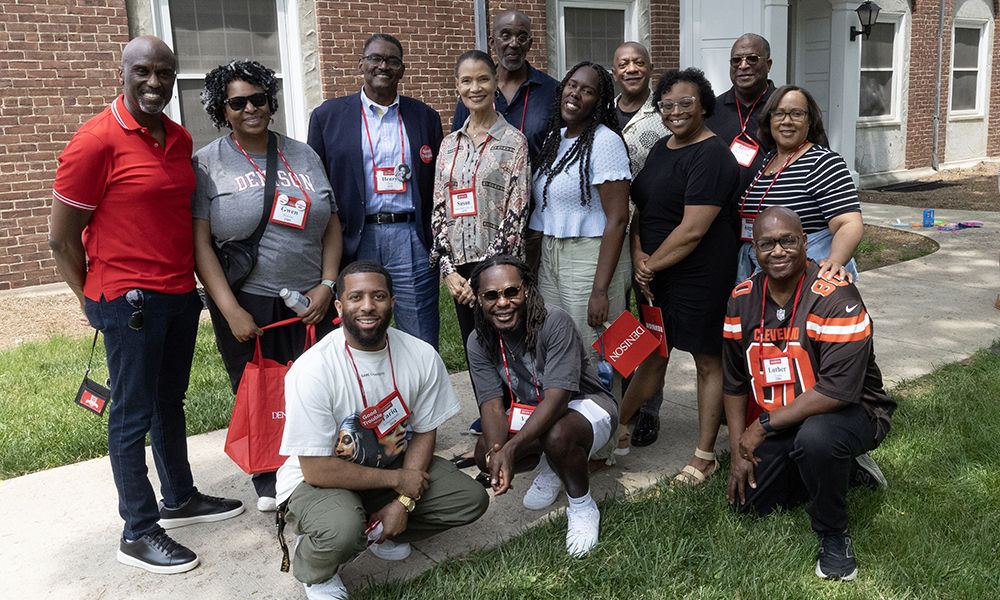 A group of alumni gather together and pose for a photo.