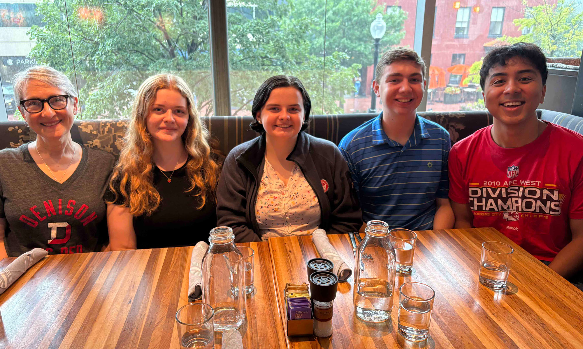 Julia Smith '28 and a group of friends pose for a photo, sitting at a restaurant table.