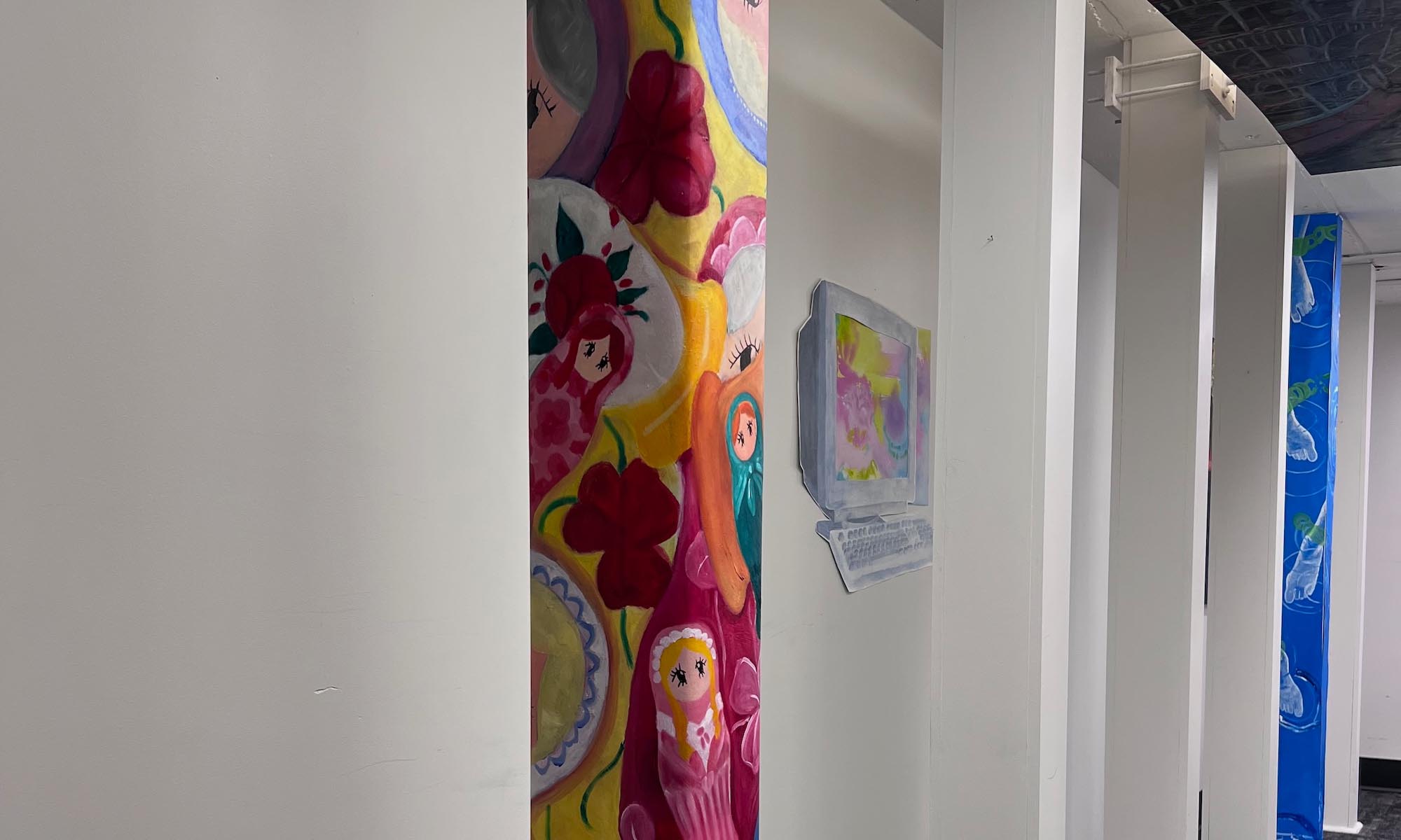 Art displayed on pillars in the Denison Libraries' throughway.