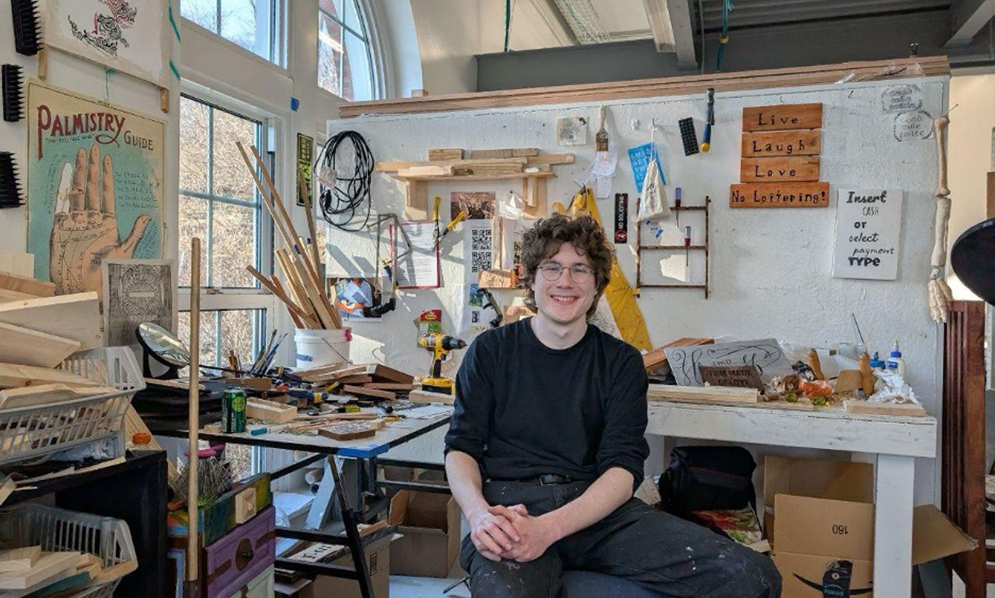 An art student sitting at his studio workstation.