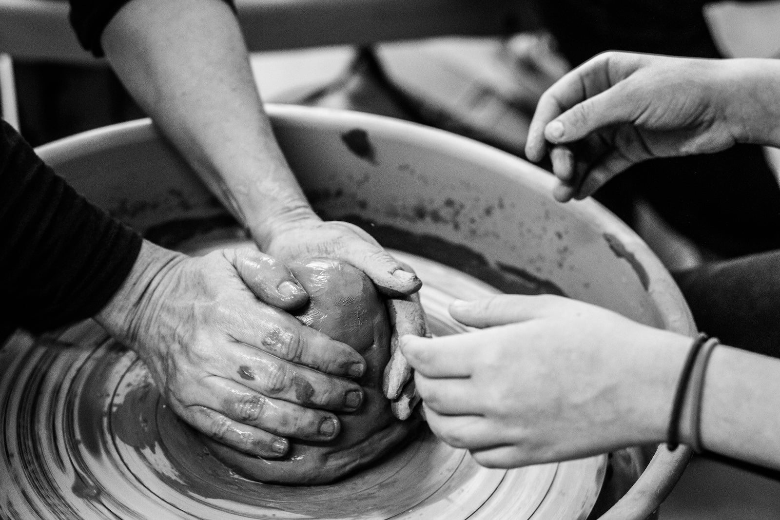 Hands shaping clay on a pottery wheel