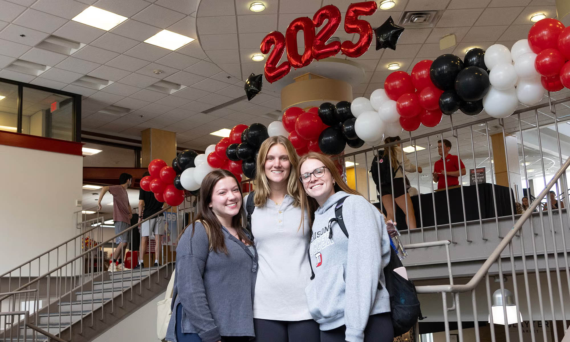Seniors pose for a photo under the 2025 balloons in Slayter