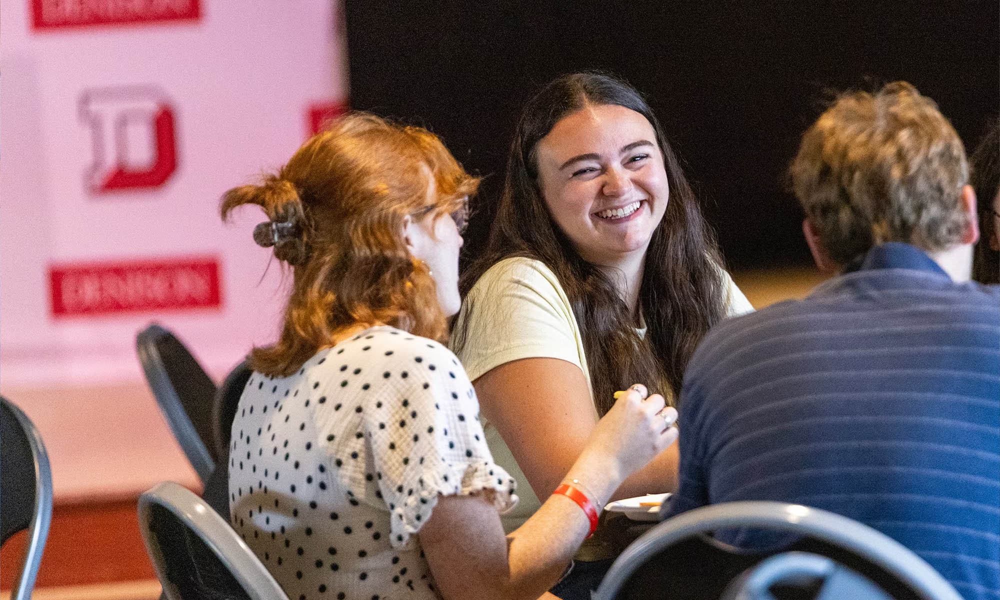 Students smile at one another at the table.