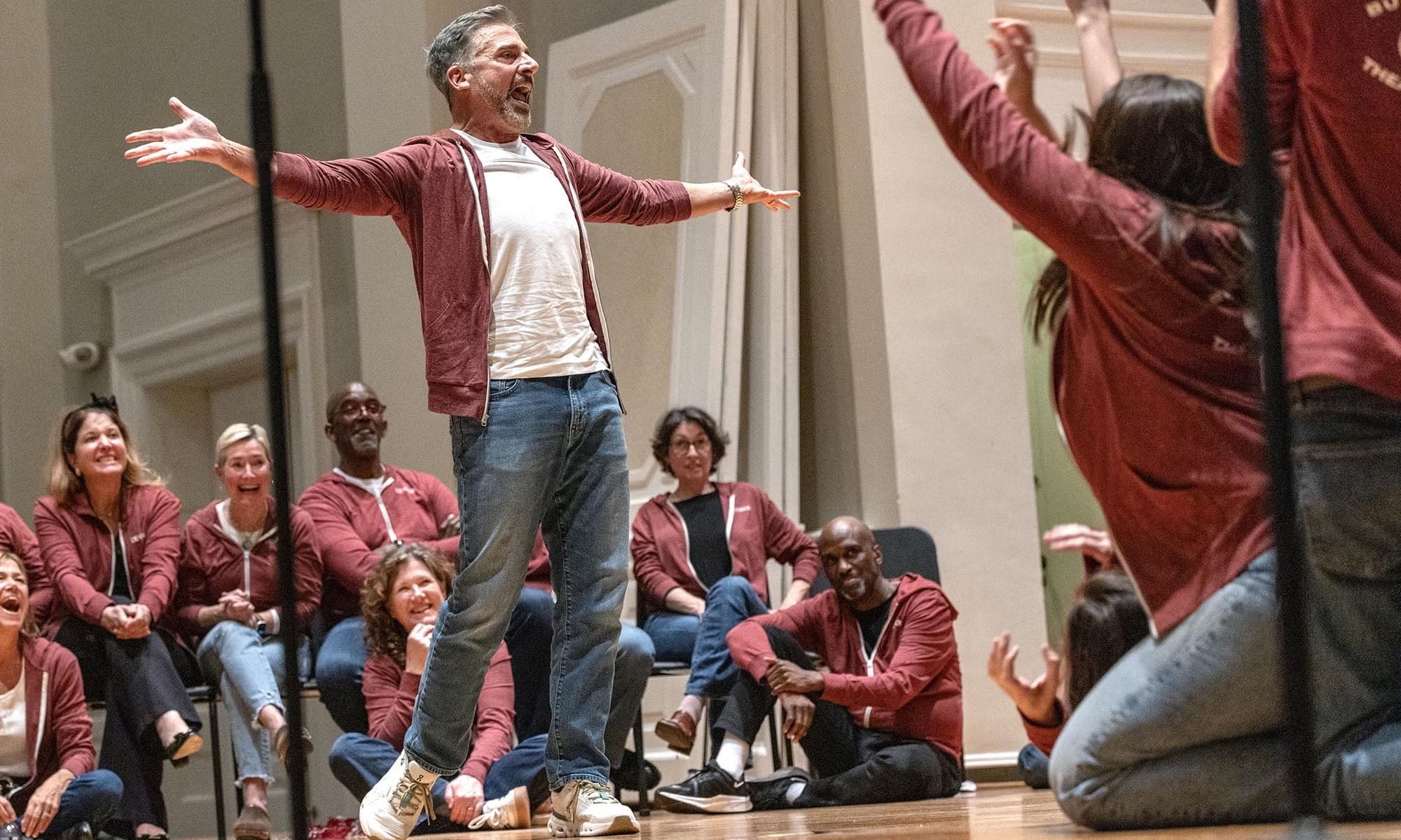 Actor Steve Carell '84 stands on the stage in Swasey Chapel with students and alums performing with the Burpees.
