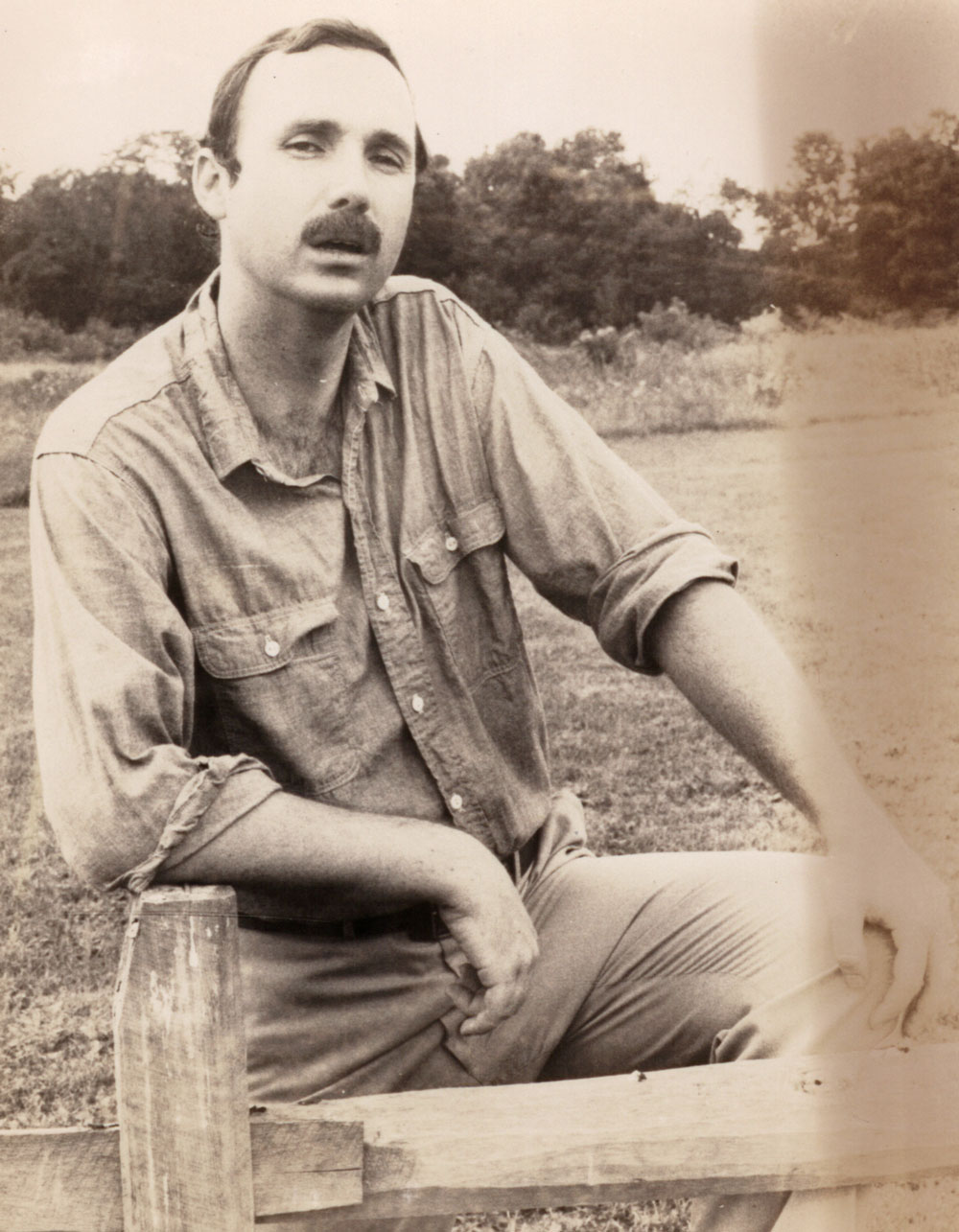 Sepia photo of young Gary with dark hair and a mustache.