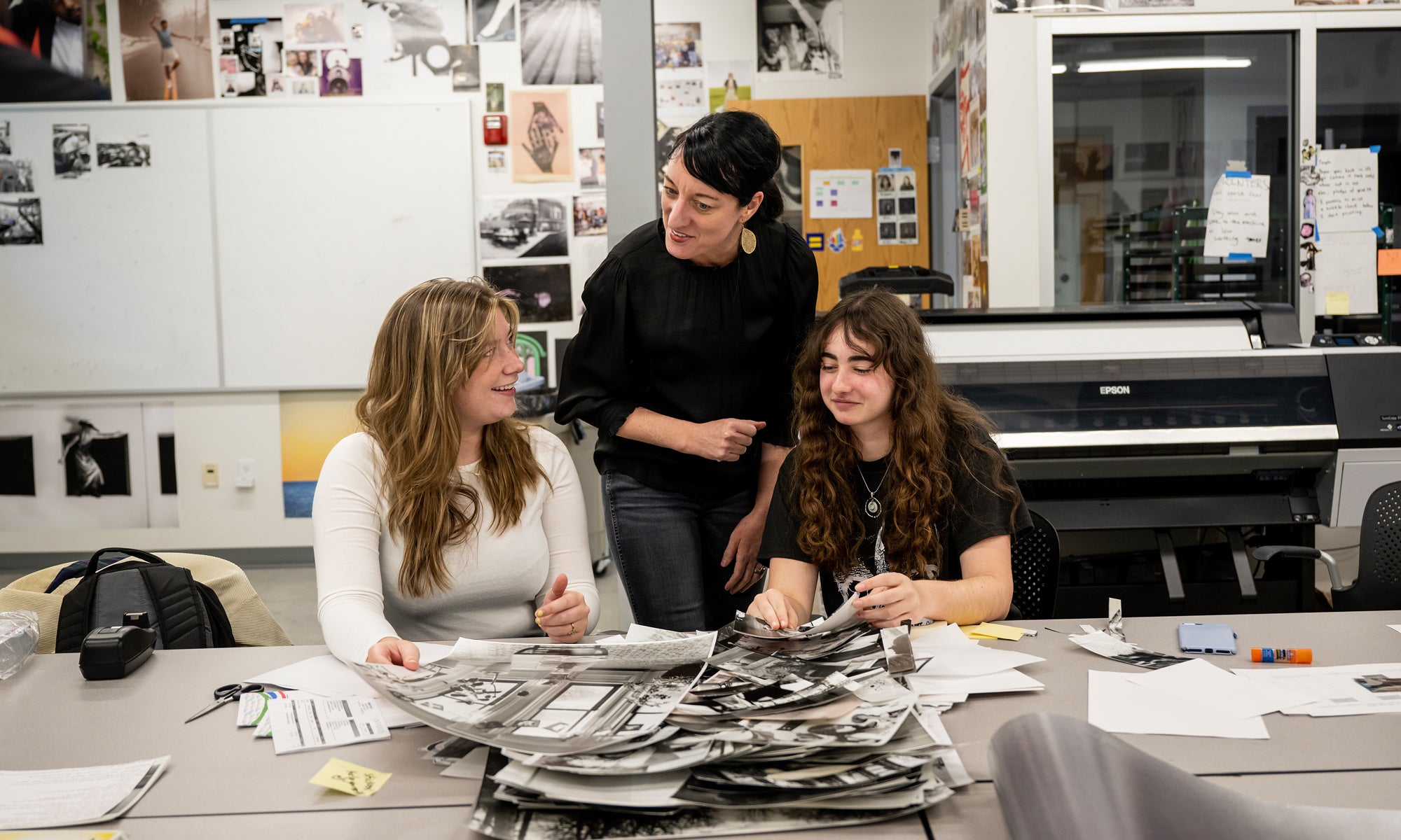 A faculty member works with two students in an art studio.