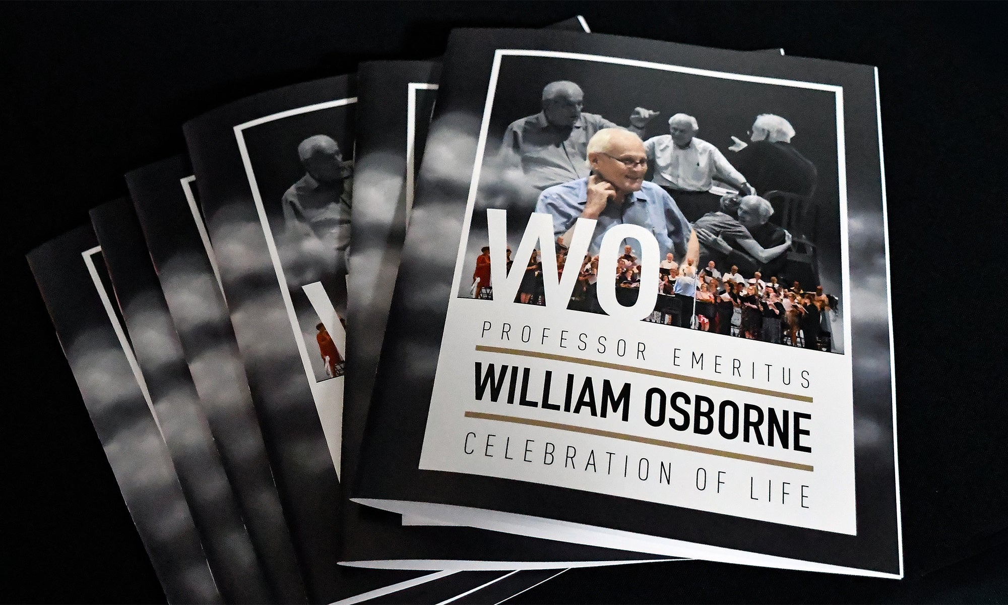 Several printed memorial booklets are stacked, each featuring the name Professor Emeritus William Osborne and the phrase Celebration of Life on the cover, along with photos of the person honored.