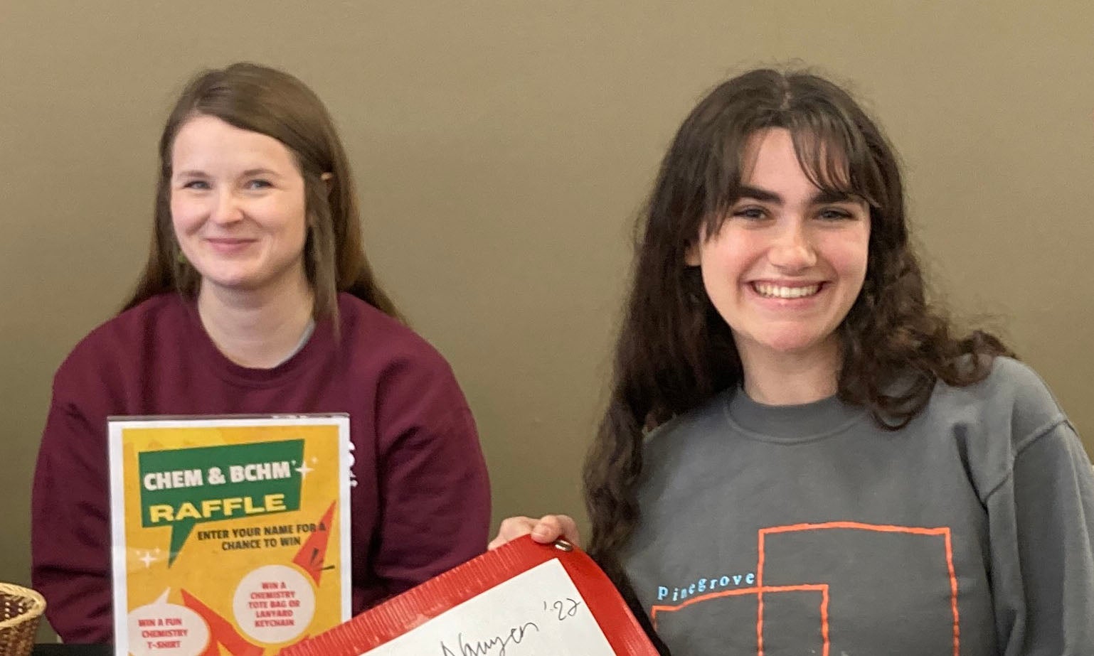 Two Chemistry / Biochemistry majors welcome students to their table.