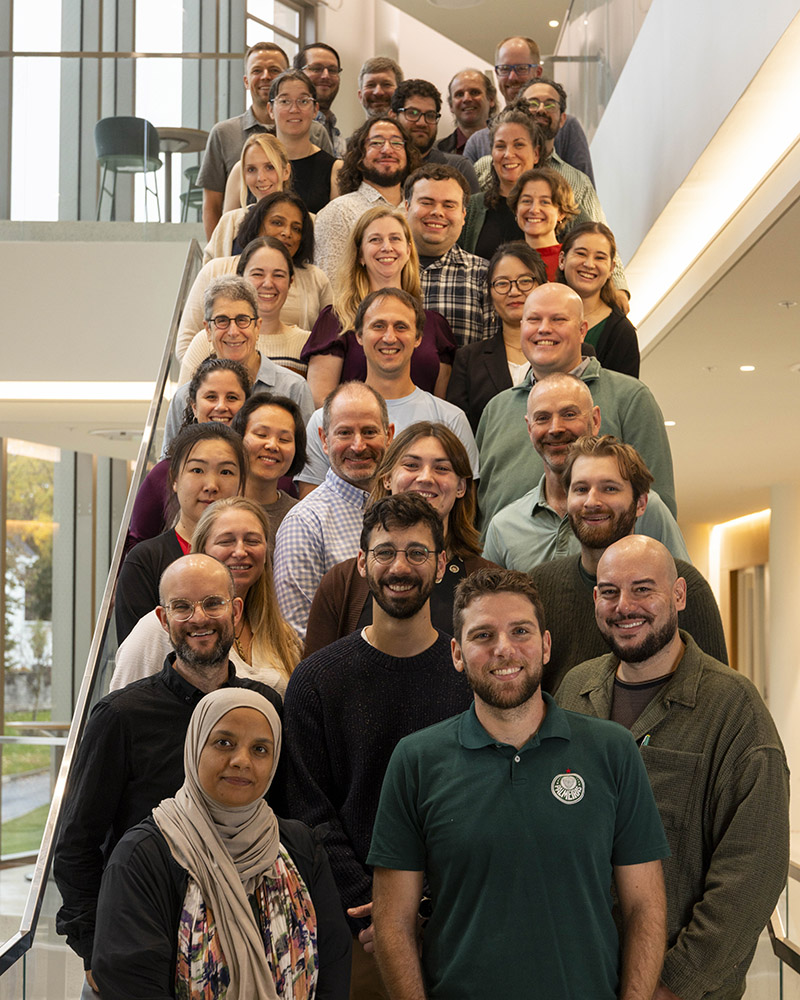 A large group of people posing for a photo on an indoor staircase.