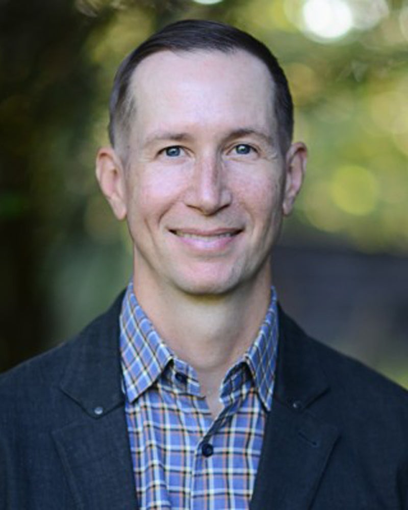 David Beaver in a blue plaid shirt and sport coat.