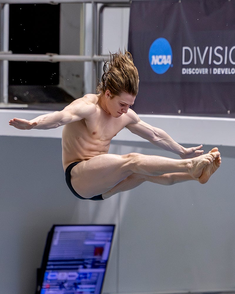 A diver, mid-flip, arms and legs extended.