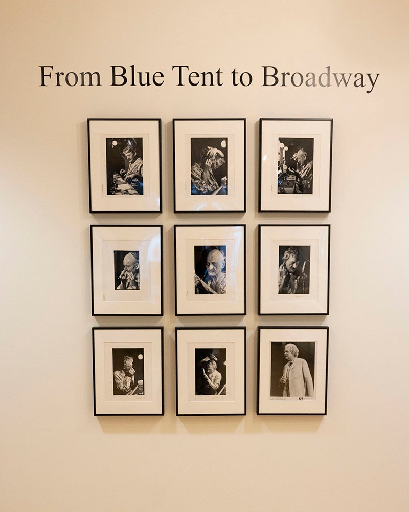 A wall display at Denison Museum features nine black-and-white framed photographs arranged in a 3x3 grid under the text, From Blue Tent to Broadway.