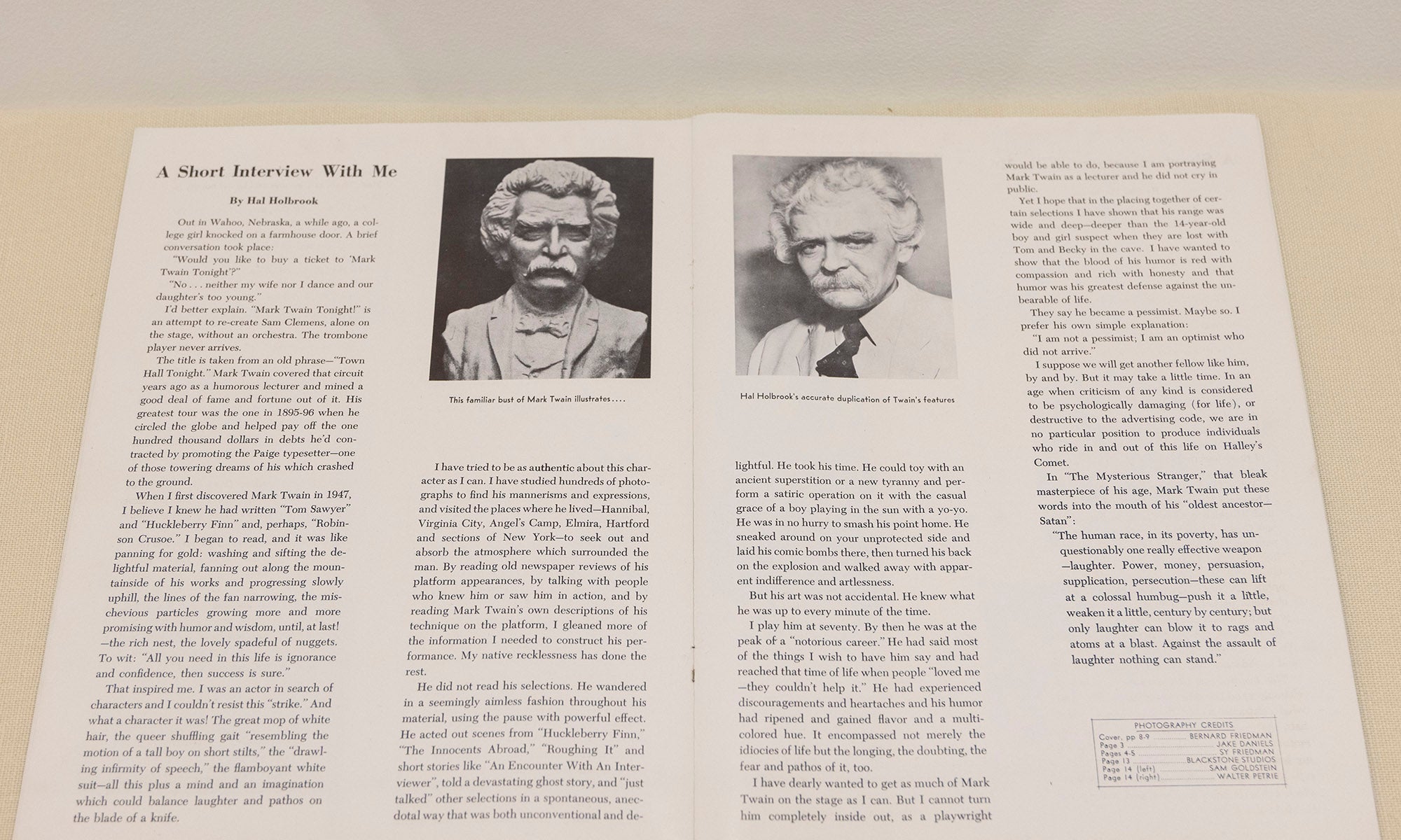 Open book or magazine spread featuring text and two black-and-white portrait photographs. The left page has a photo of a man with a mustache; the right page includes an older man in a suit and tie, as seen in the Denison Museum’s Blue Tent exhibit.