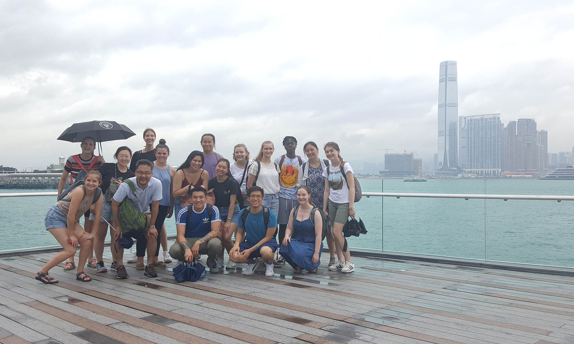 A large group of study abroad students standing on a pier overlooking Hong Kong.