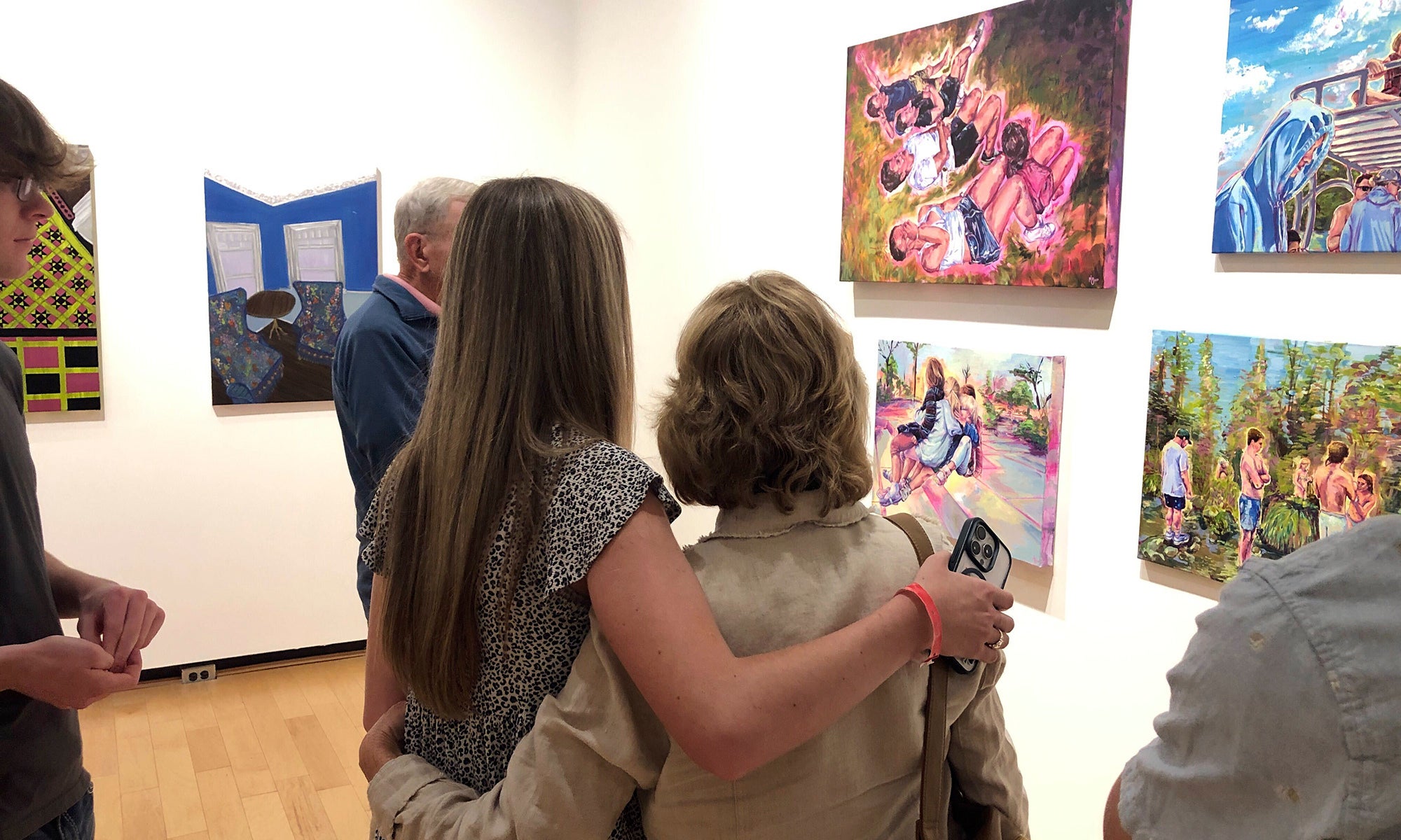 A student artist shows her work to family at the Denison Museum.