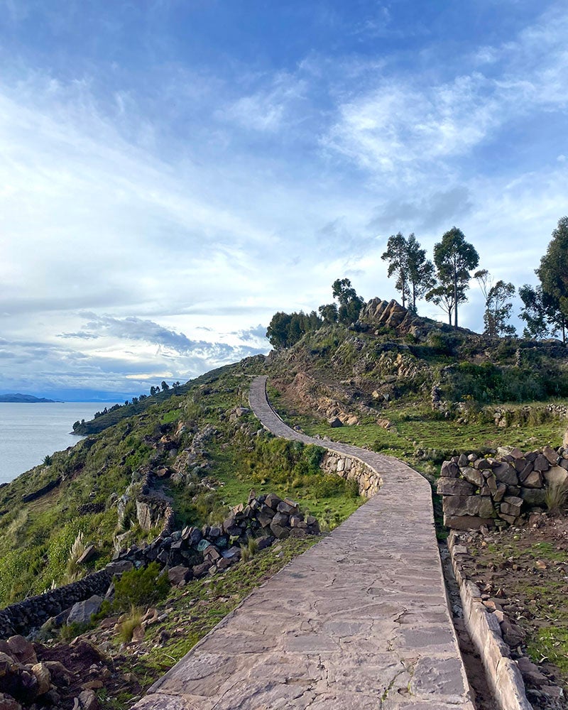 A path leading up a hill near a lake