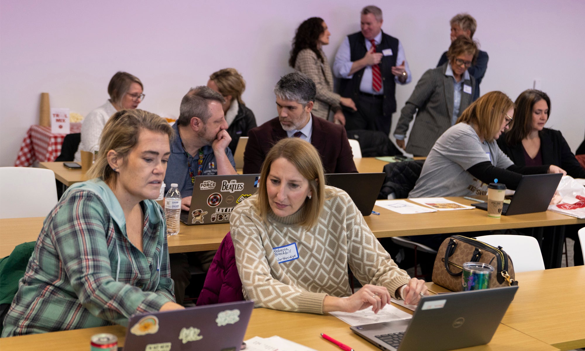 Workshop attendees gathered in small groups discussing AI topics.