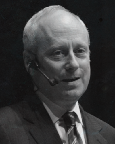 Black and white photo of Michael Sandel speaking at an event,