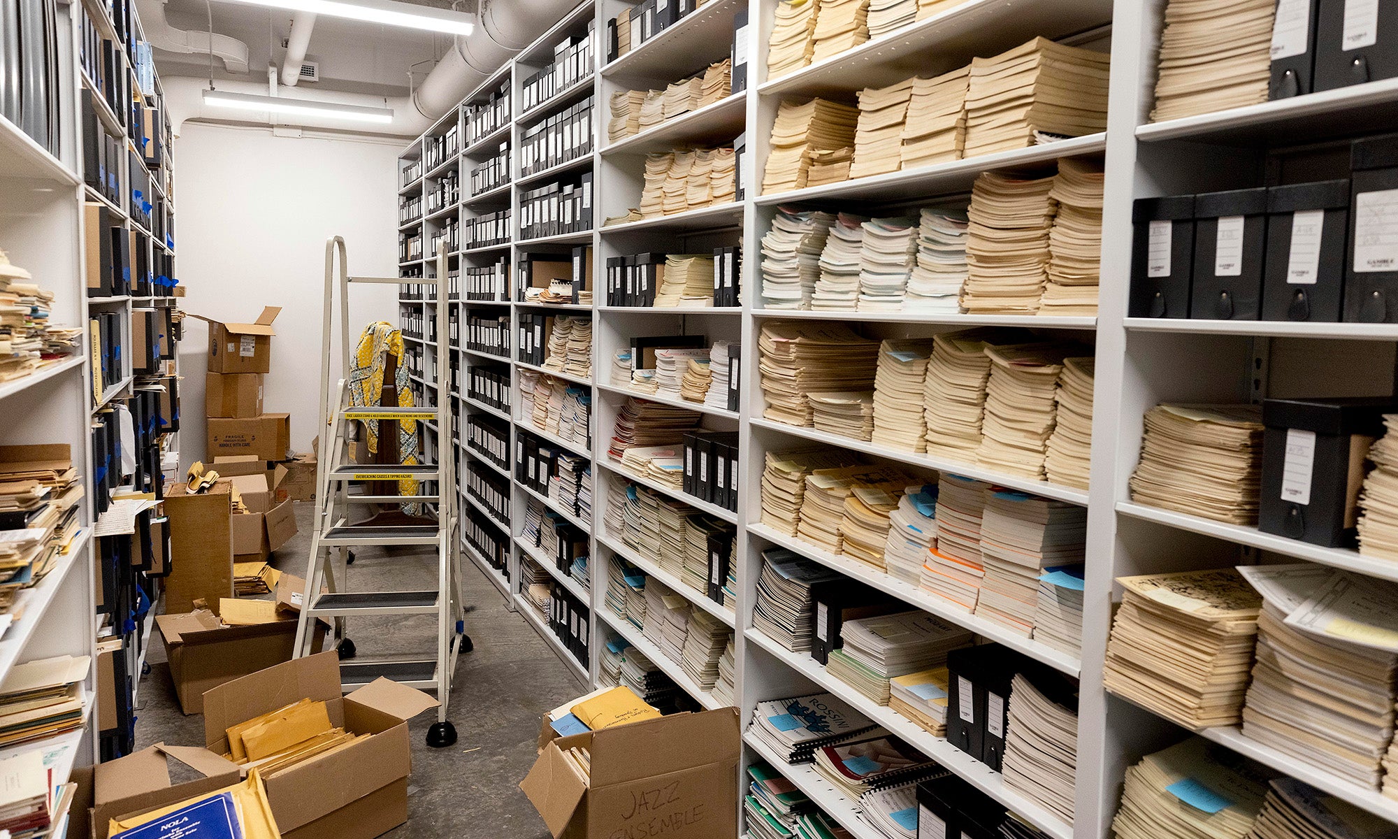 Shelves filled with stacks of boxes and sheets of music.
