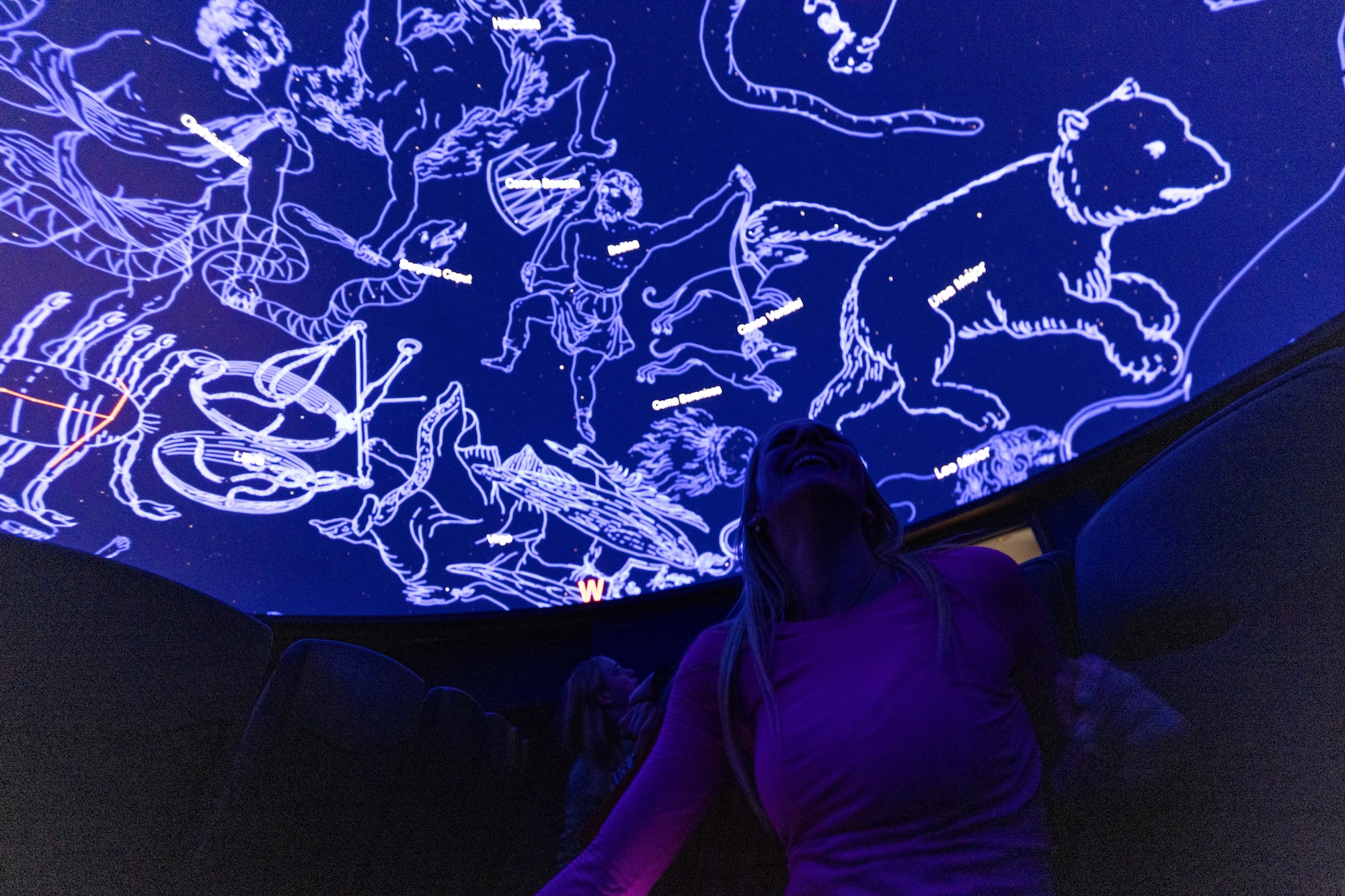 A woman looks up during a show at the planetarium