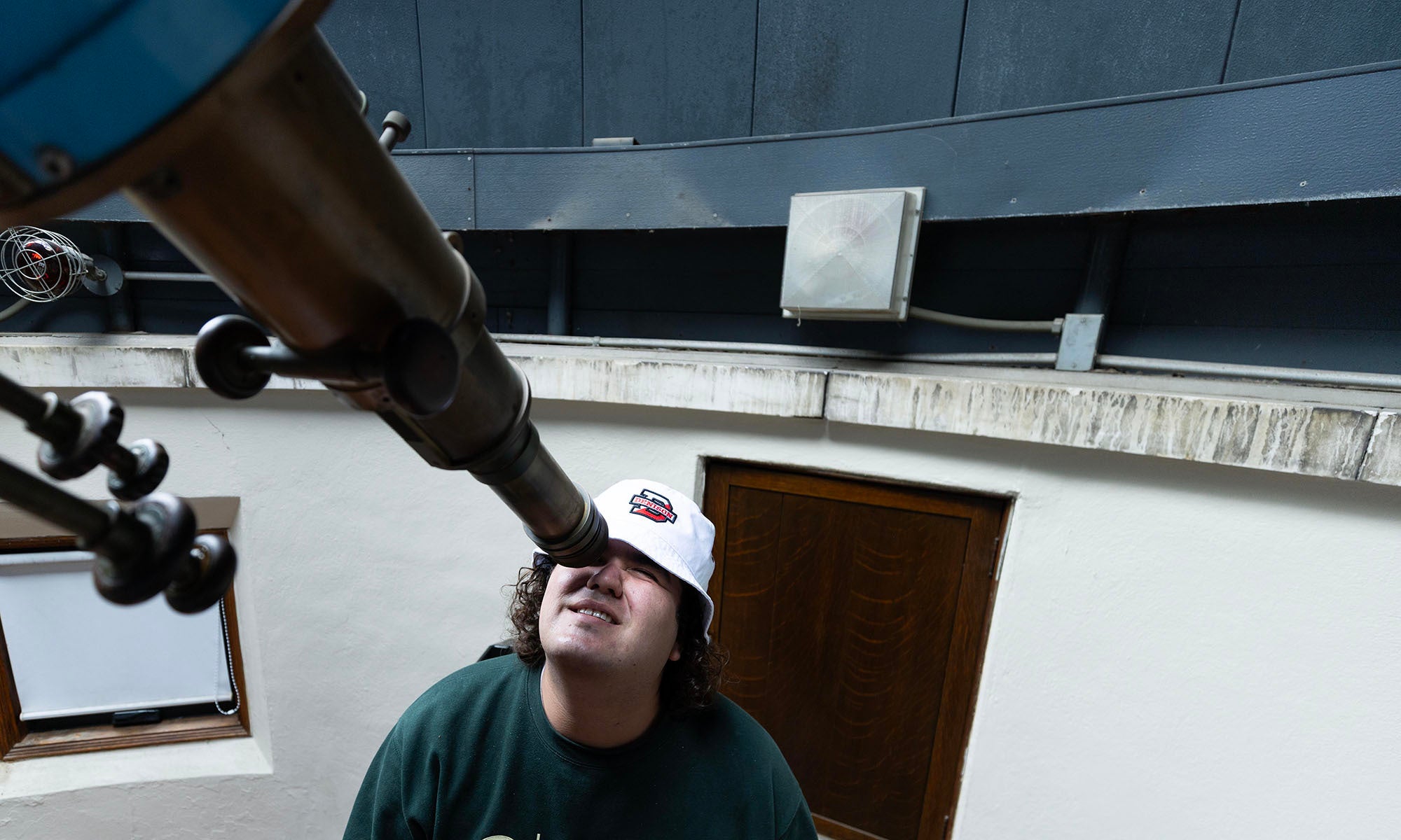 A student peers through a telescope at Swasey Observatory.