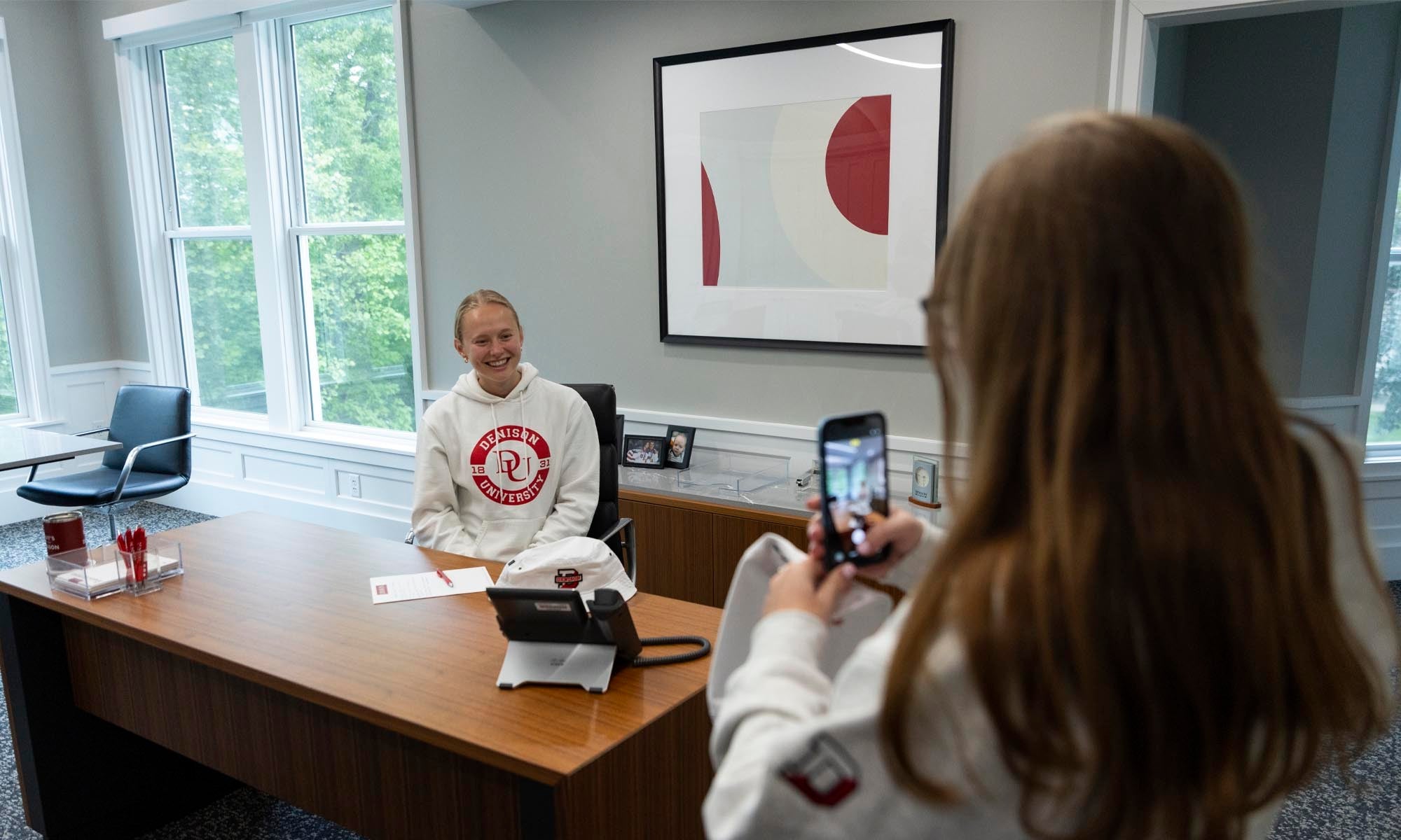 A Denison senior enjoys some time sitting at President Weinberg's desk.