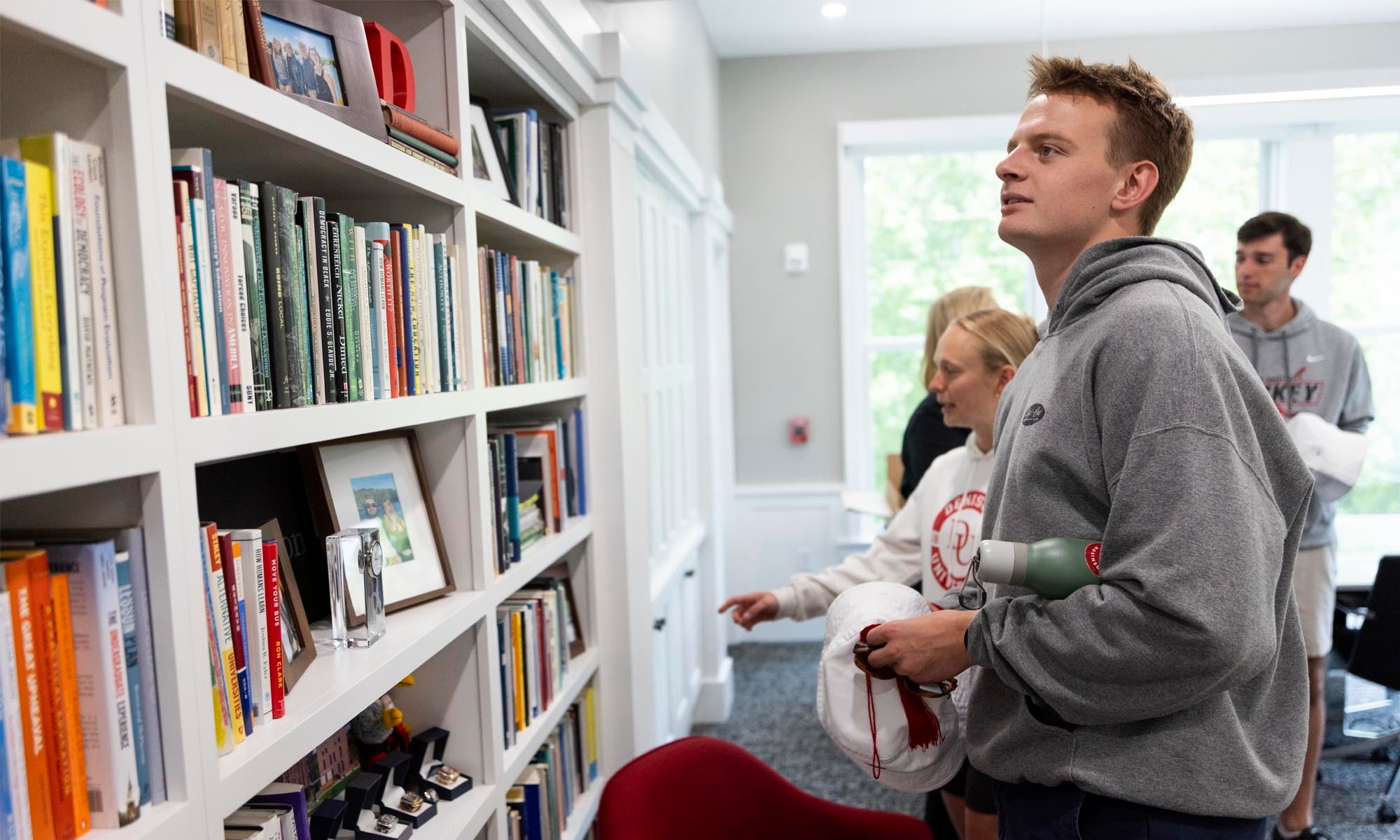 Graduating seniors peruse the bookshelves in President Weinberg's office.