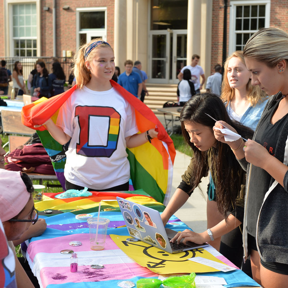 Student with pride flag at the involvement fair